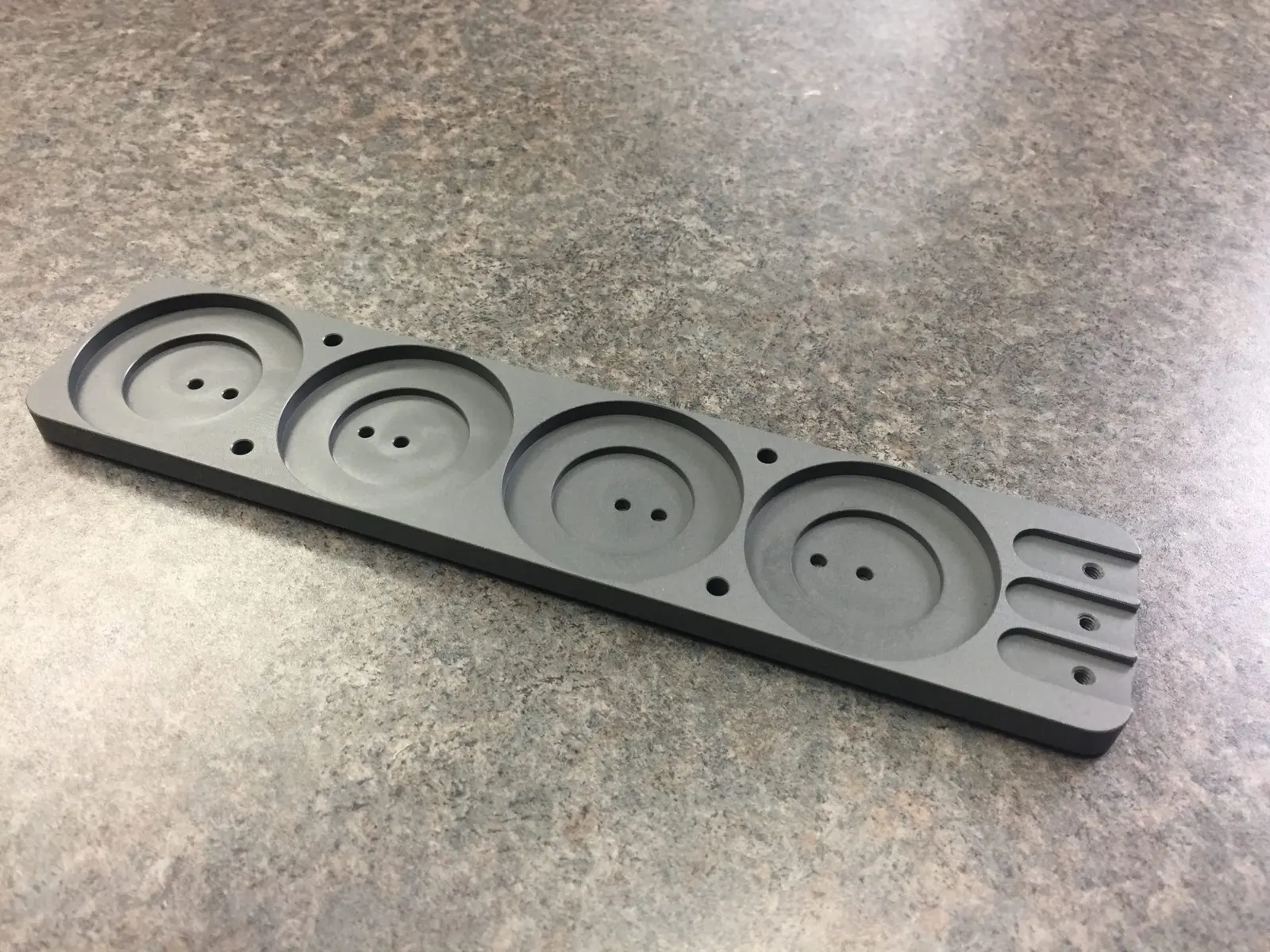 Grey four-pocket machined plate